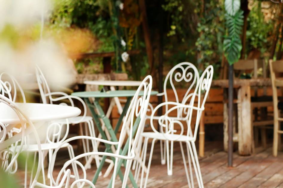 Rustic wooden garden table with potted plants and outdoor chairs on a sunny patio