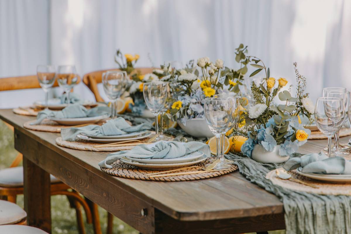 easy garden ideas and designs featuring a weather-sealed wooden garden table surrounded by potted herbs and string lights
