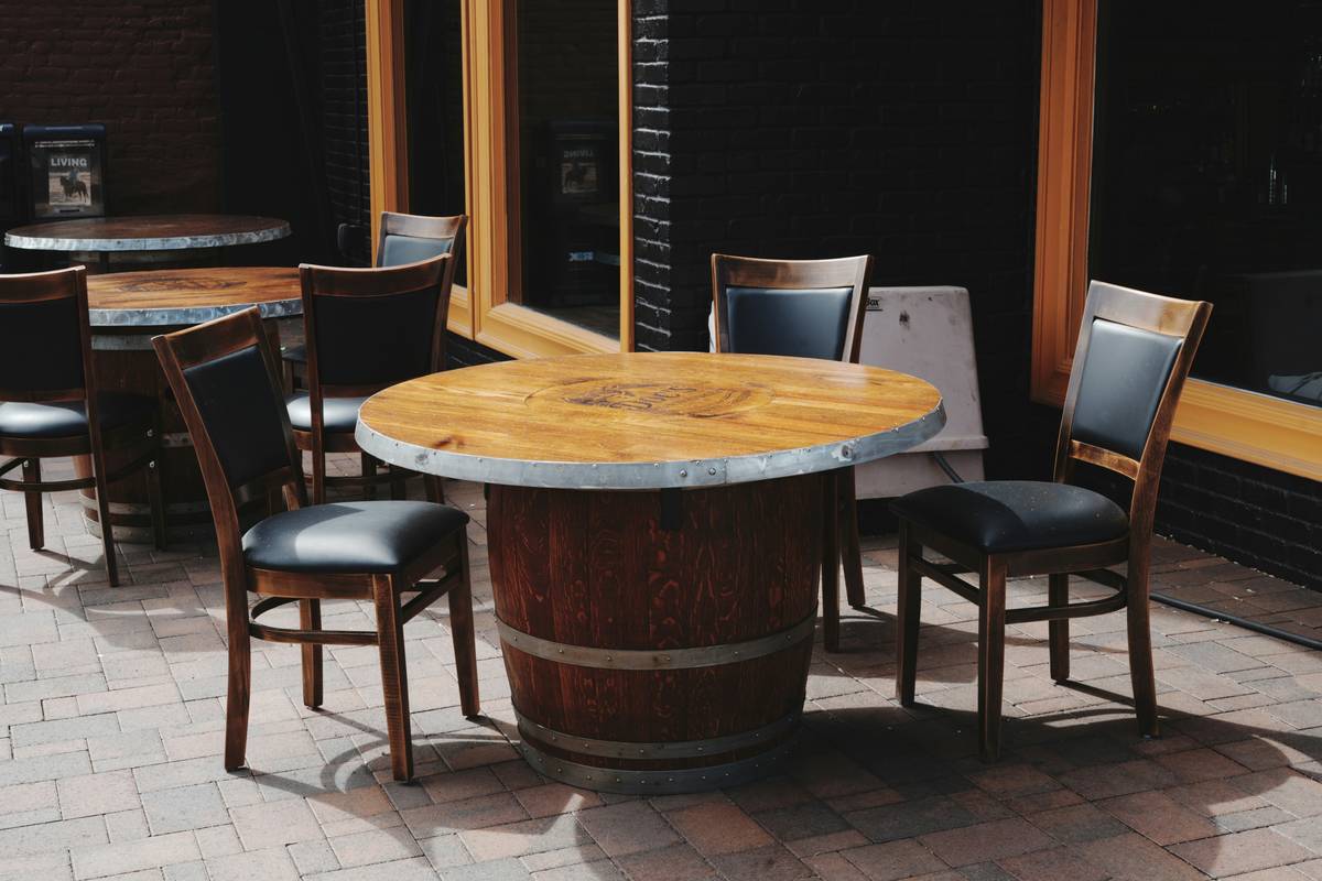 garden ideas for long gardens featuring a compact bistro table nestled between raised flower beds along a narrow pathway