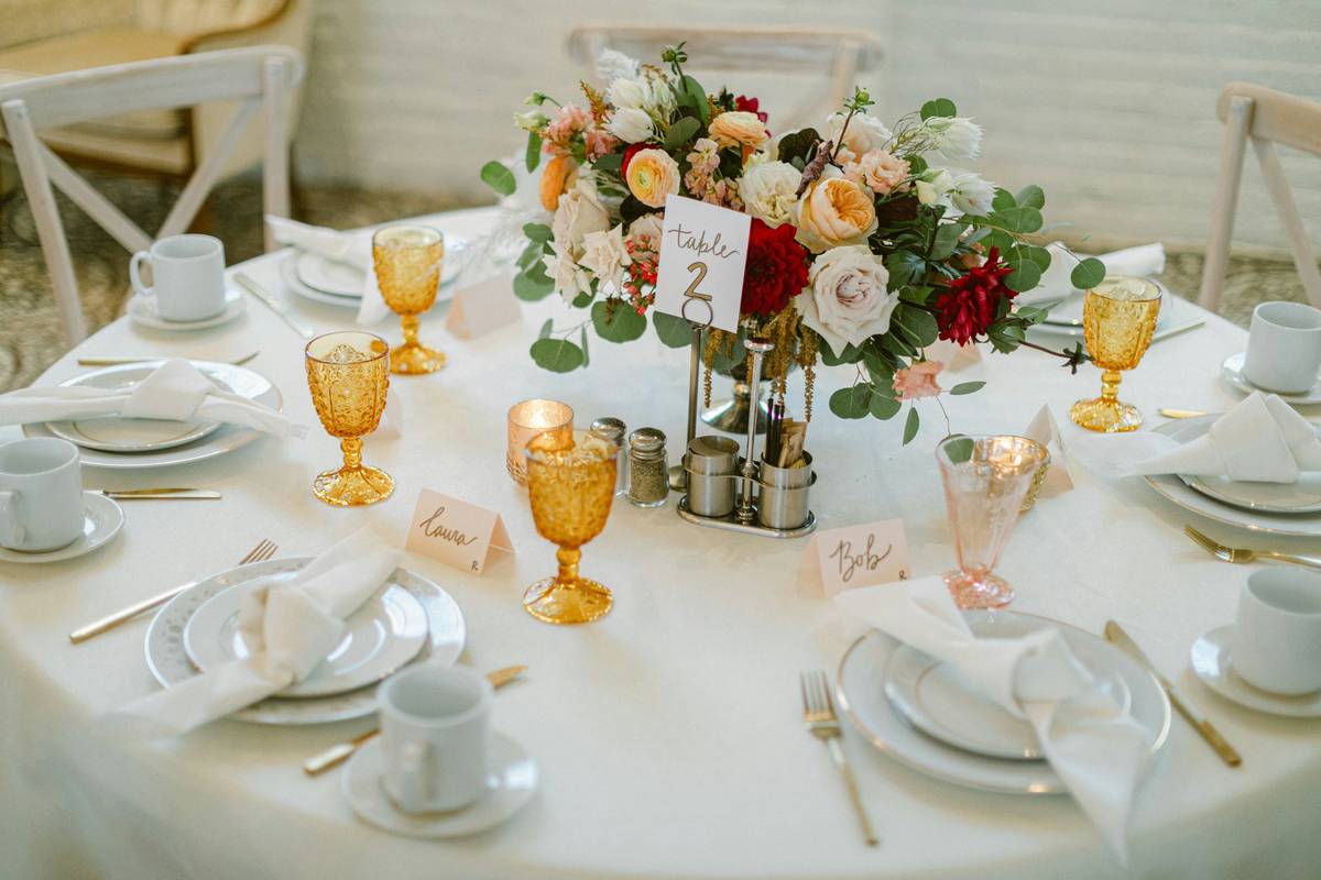 garden table centerpiece ideas featuring weather-resistant lanterns and potted herbs on a wooden patio table